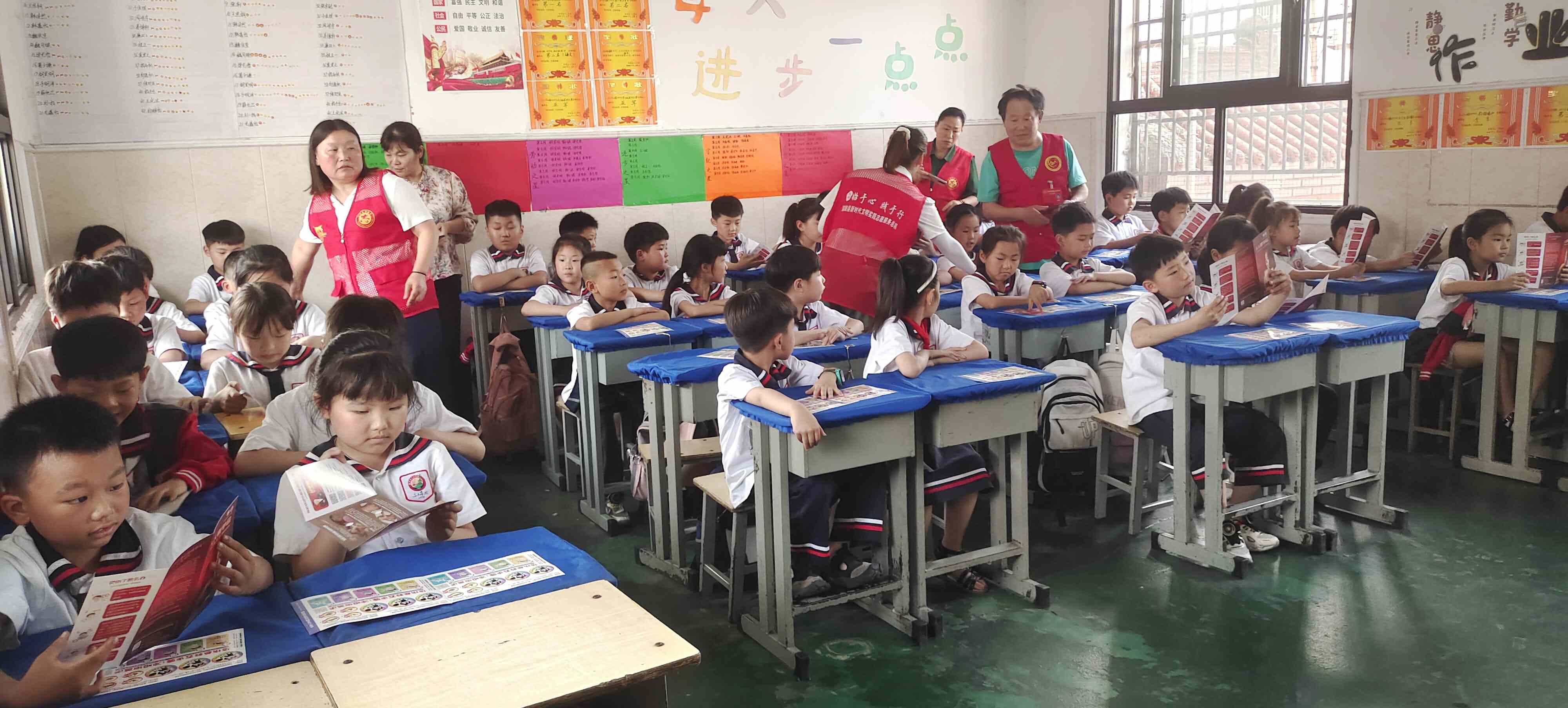 4.志愿者为学生们发放预防烧烫伤宣传册，感温贴.jpg