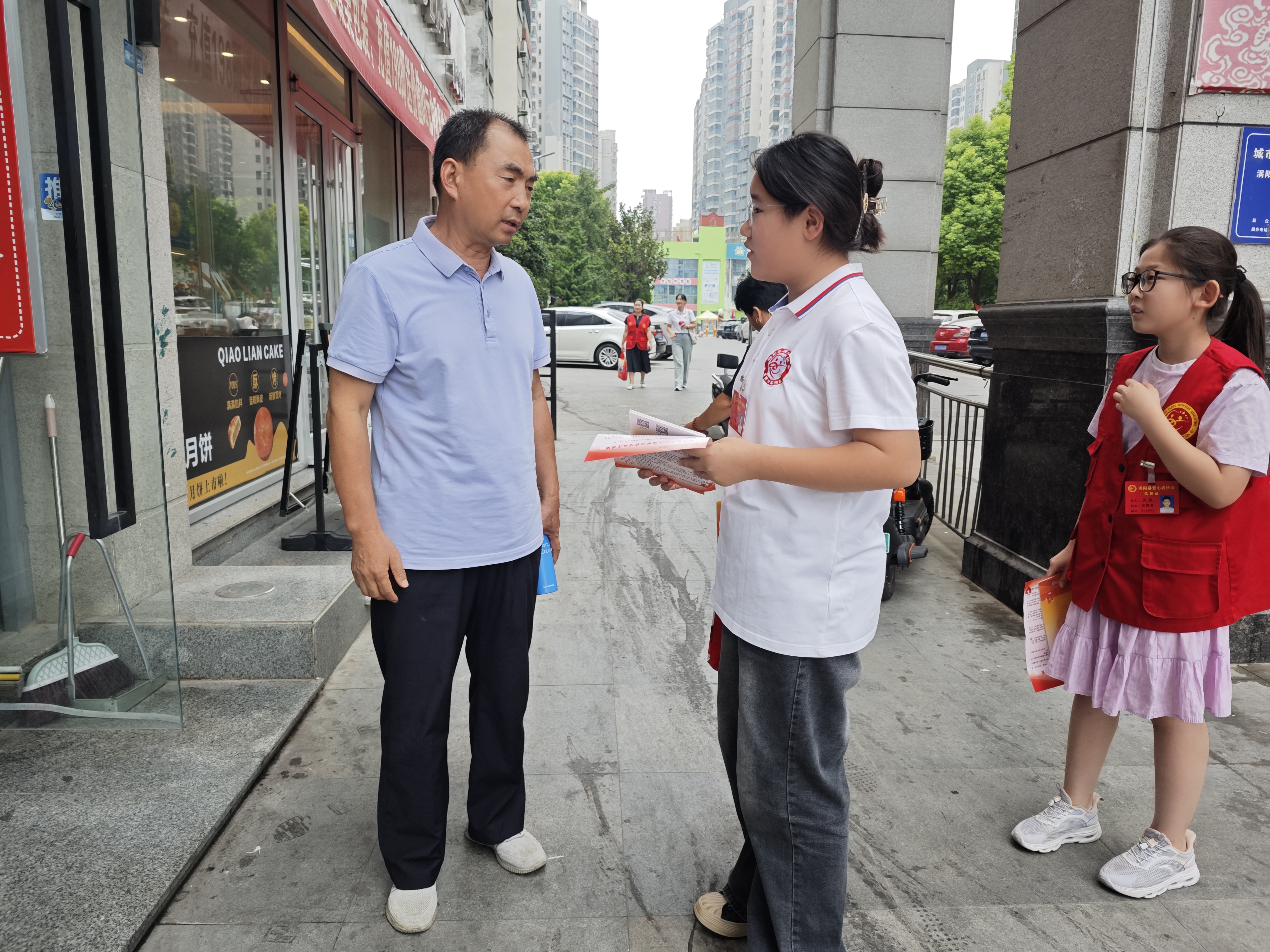 10志愿者向市民发宣传单.jpg