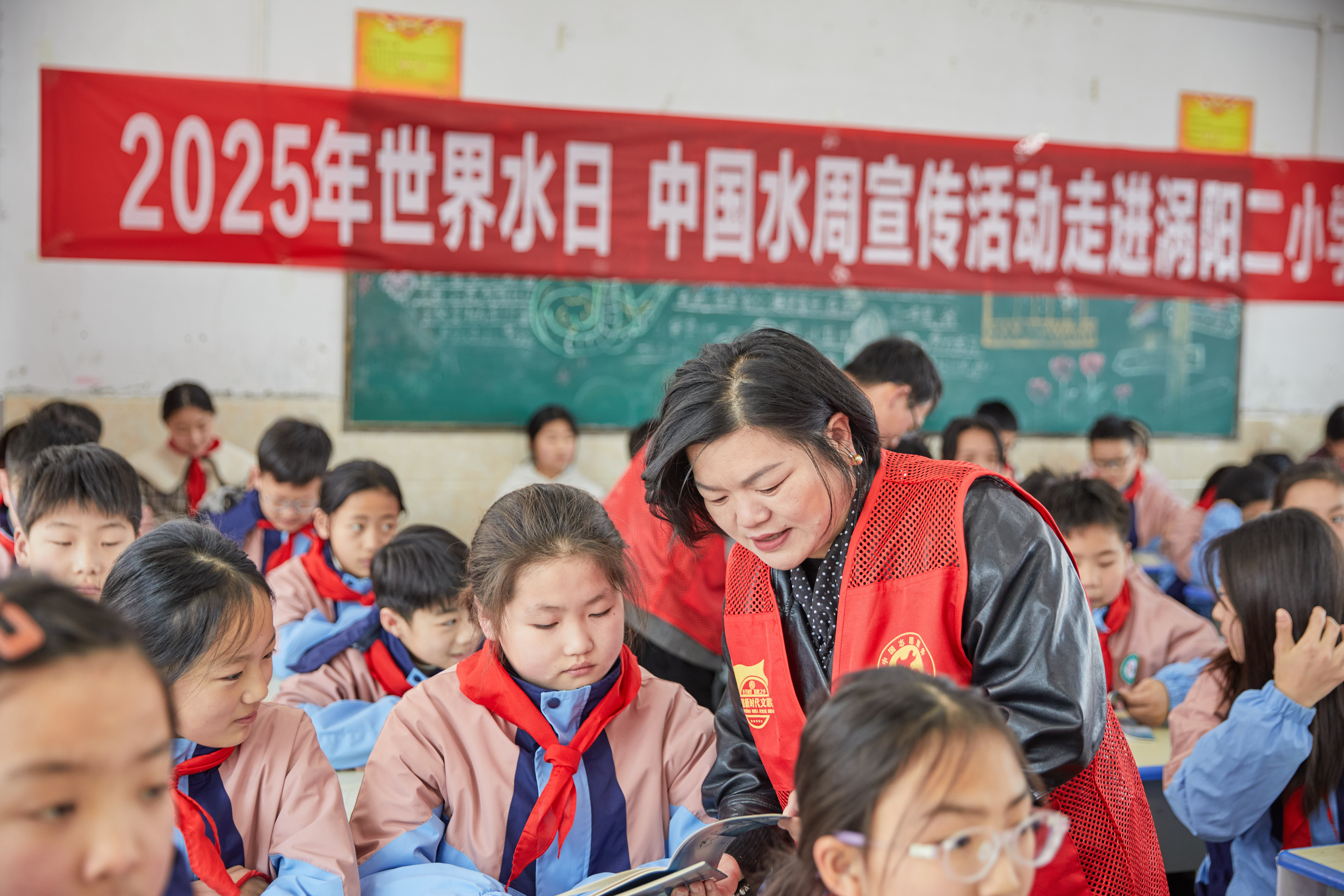 2志愿者为学生讲解科普手册中的知识.jpeg