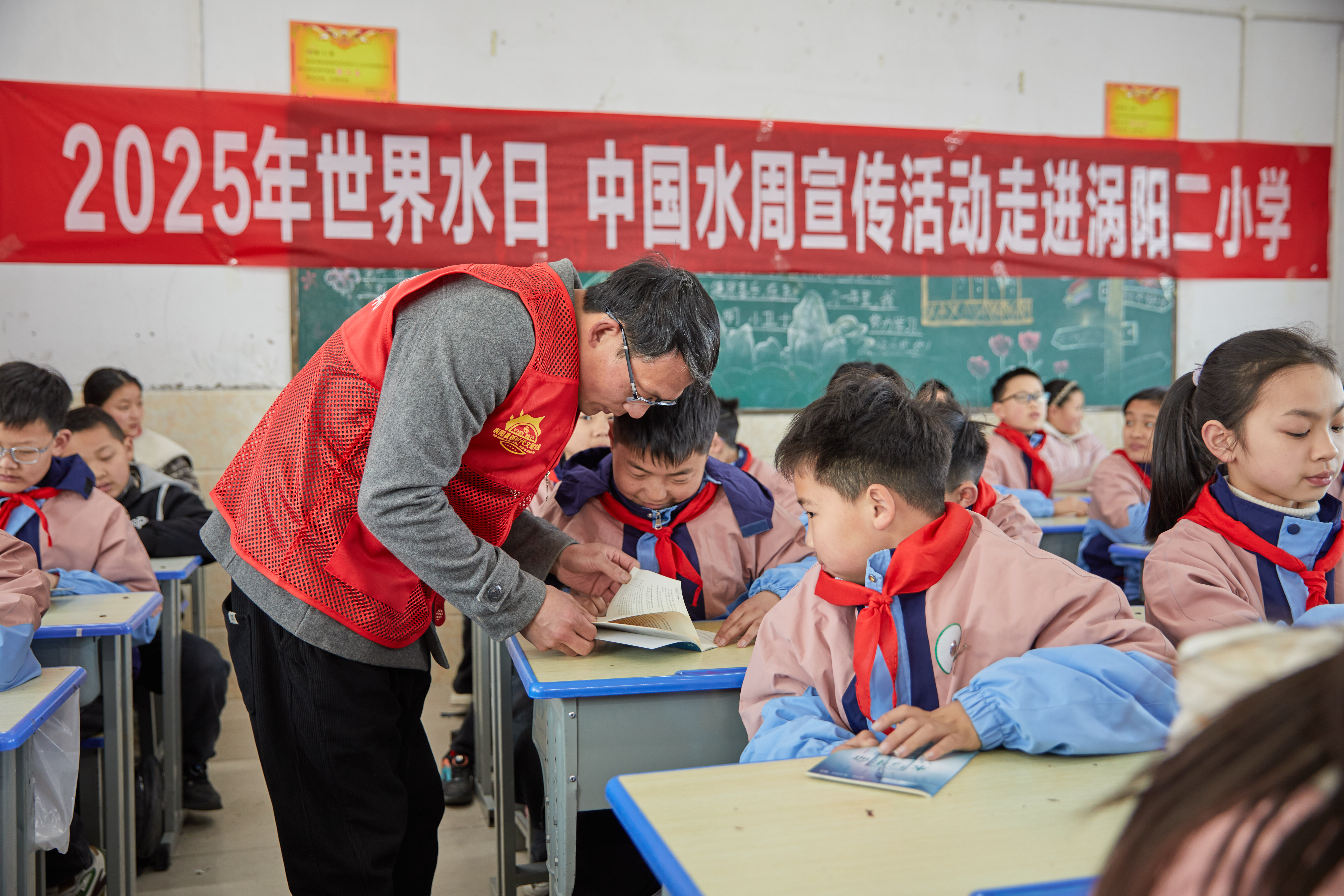 3志愿者为学生讲解科普手册中的知识.jpeg