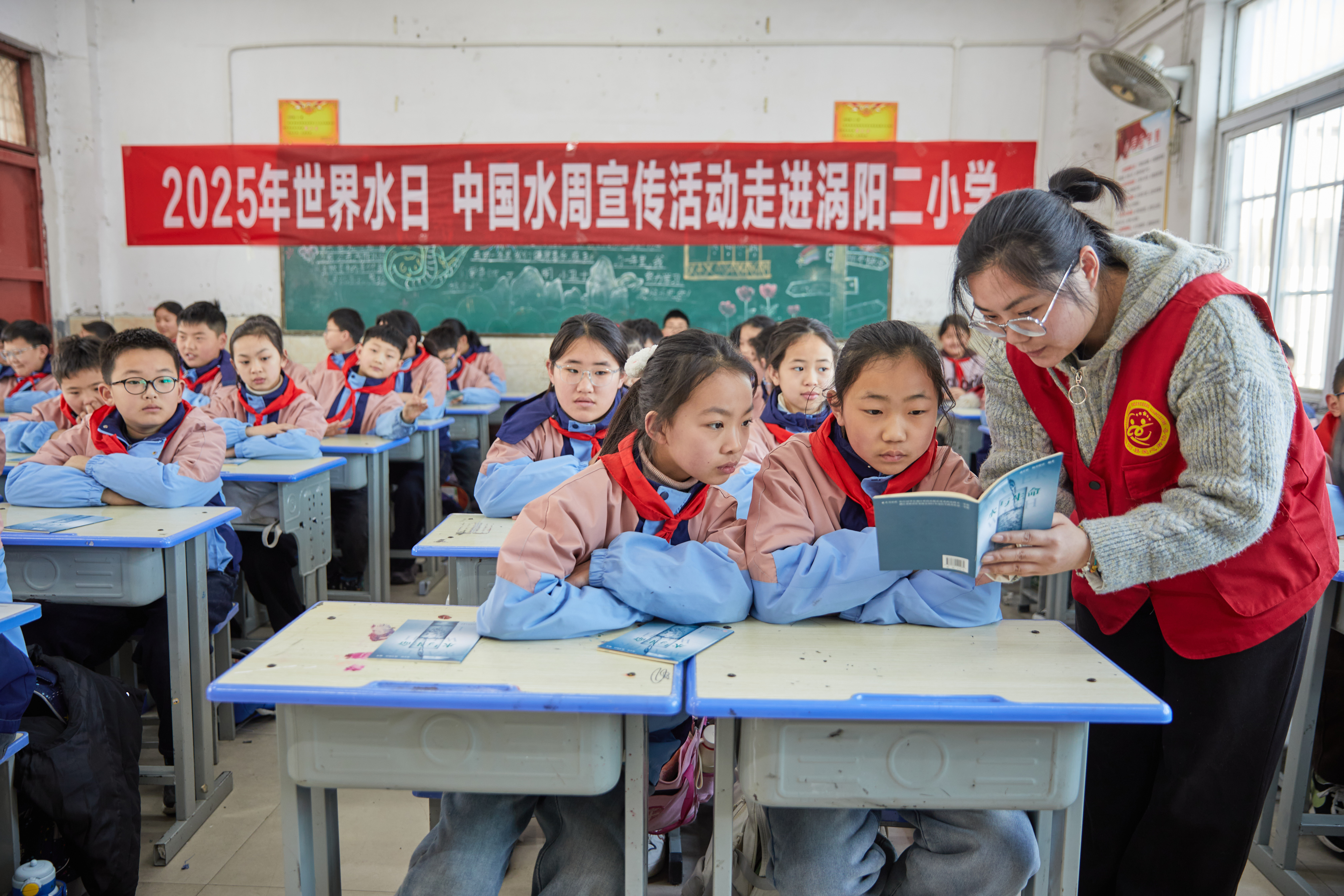 5志愿者为学生讲解科普手册中的知识.jpeg