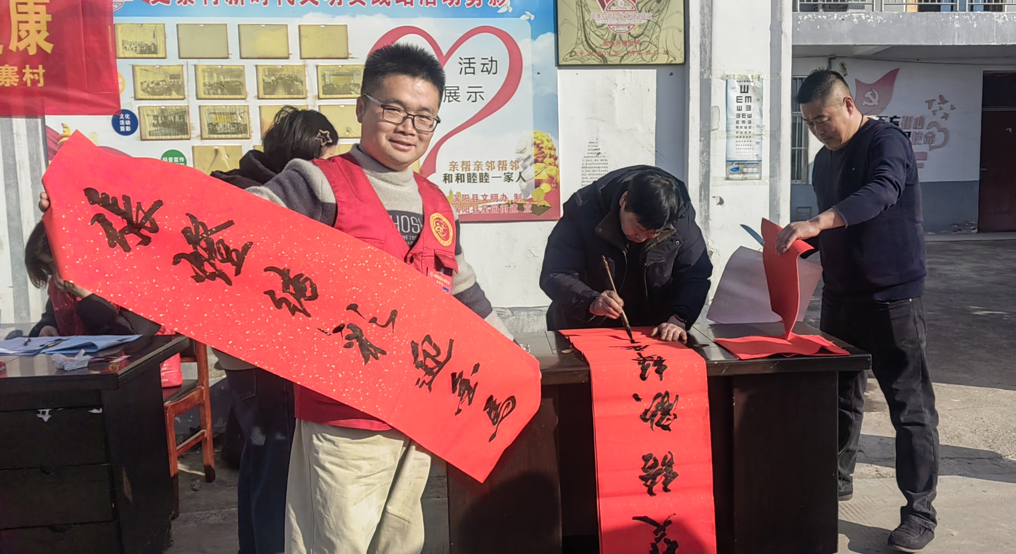 6志愿者展示写好的春联.jpg