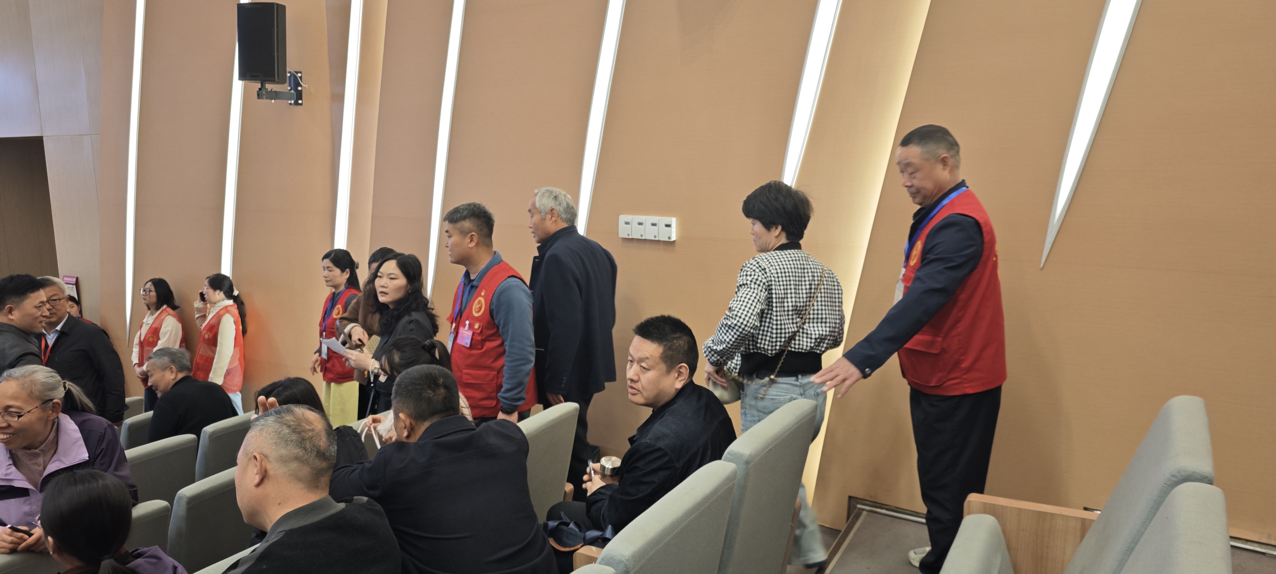 i_20260330214007485625.jpg 3志愿者引导参会人员入座.jpg