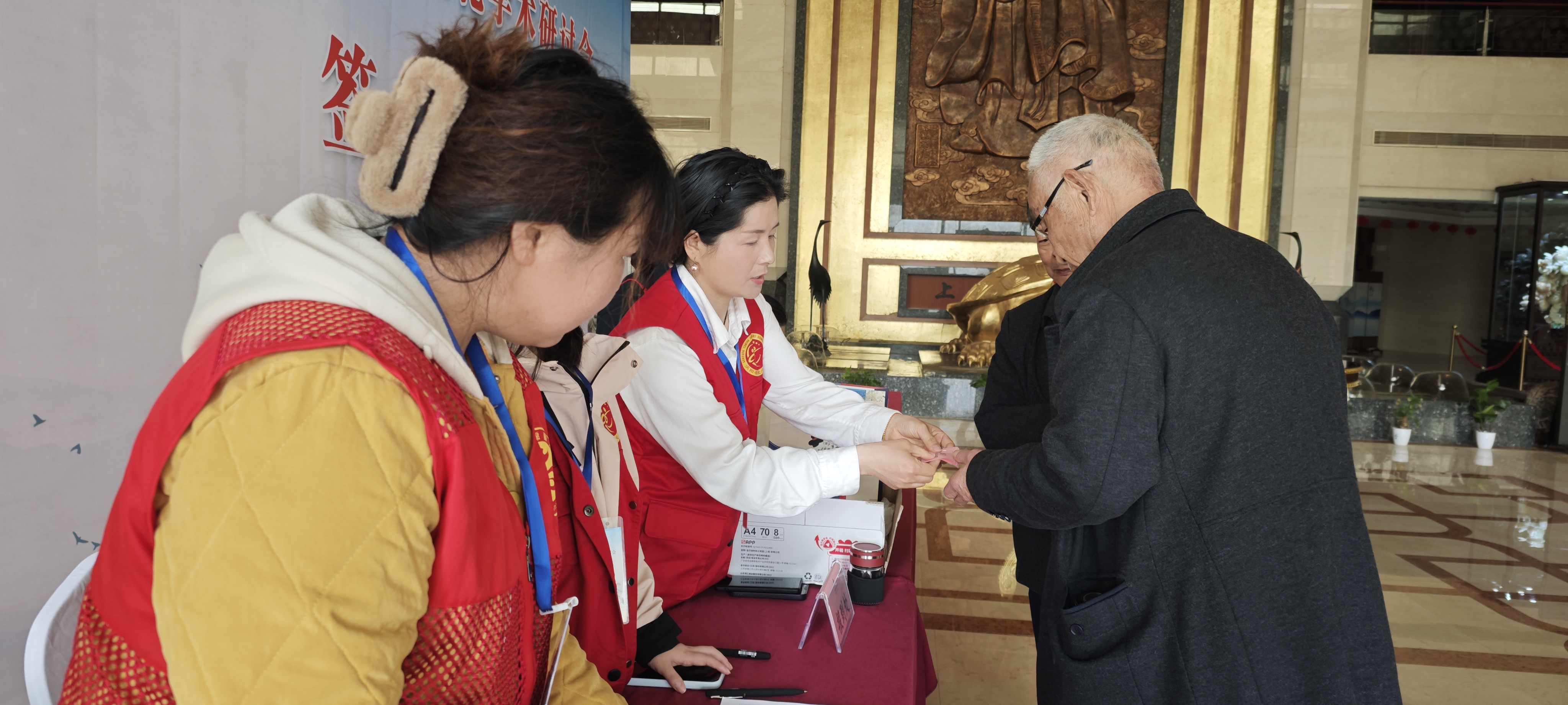 i_20260330214733396590.jpg 4志愿者为参会人员发放餐券.jpg