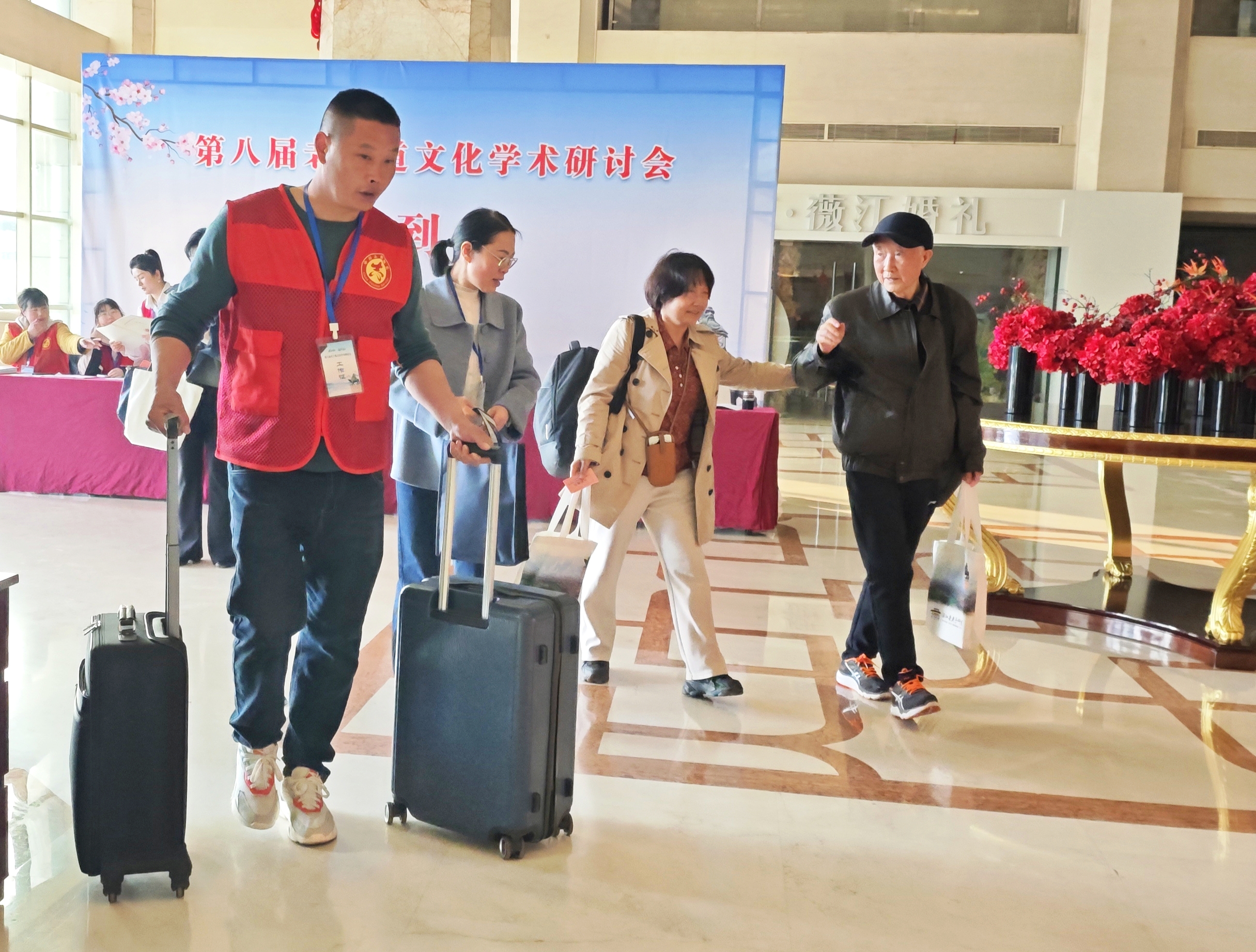 i_20260330214812229256.jpg 5志愿者为参会成员搬运行李并引导参会成员办理入住.jpg