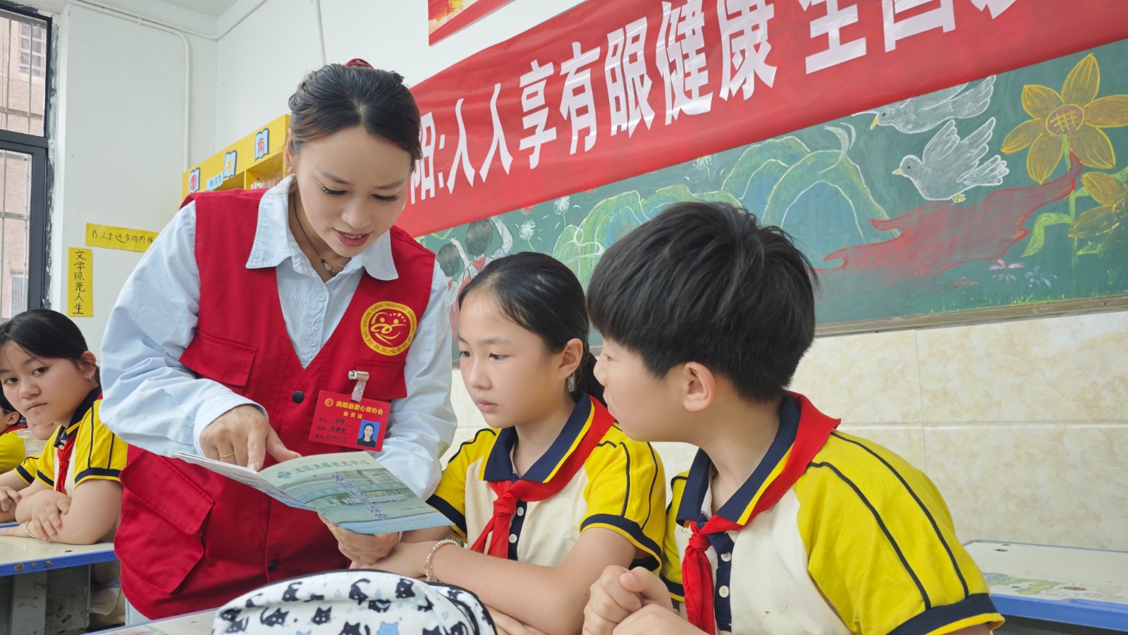 i_20260605145809339113.jpeg 2志愿者们为学生们发放爱眼护眼知识宣传册,讲解如何科学保护眼睛.jpeg
