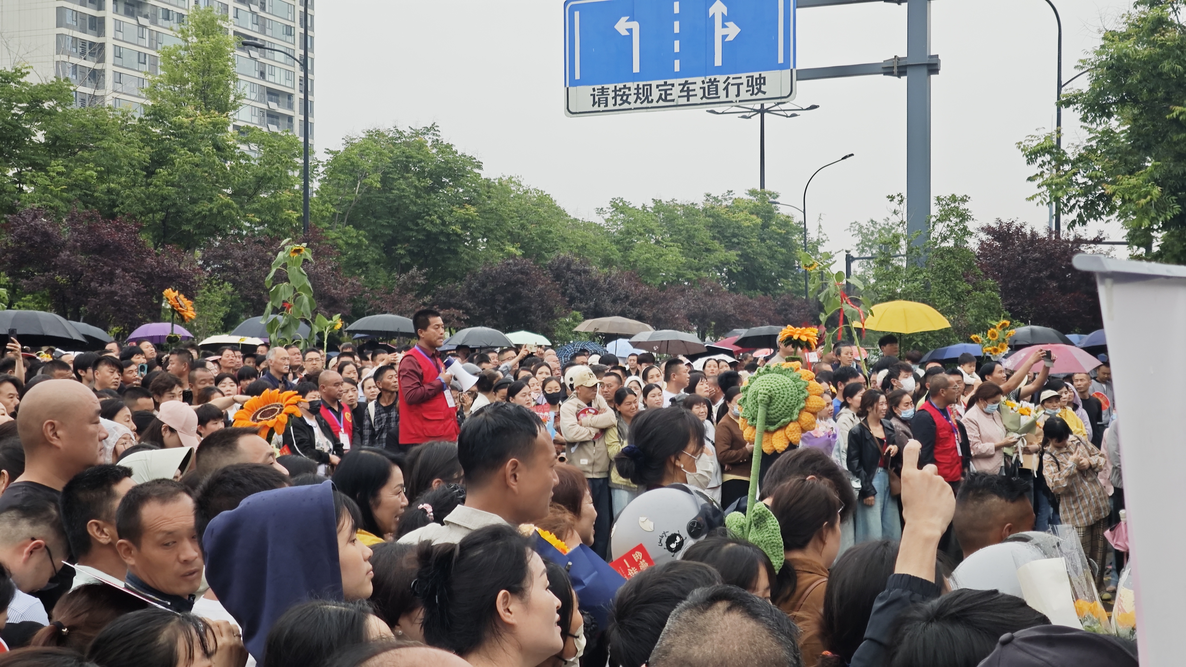 i_20260607193705162123.jpg 10.志愿者穿梭在送考家长中维持秩序.jpg