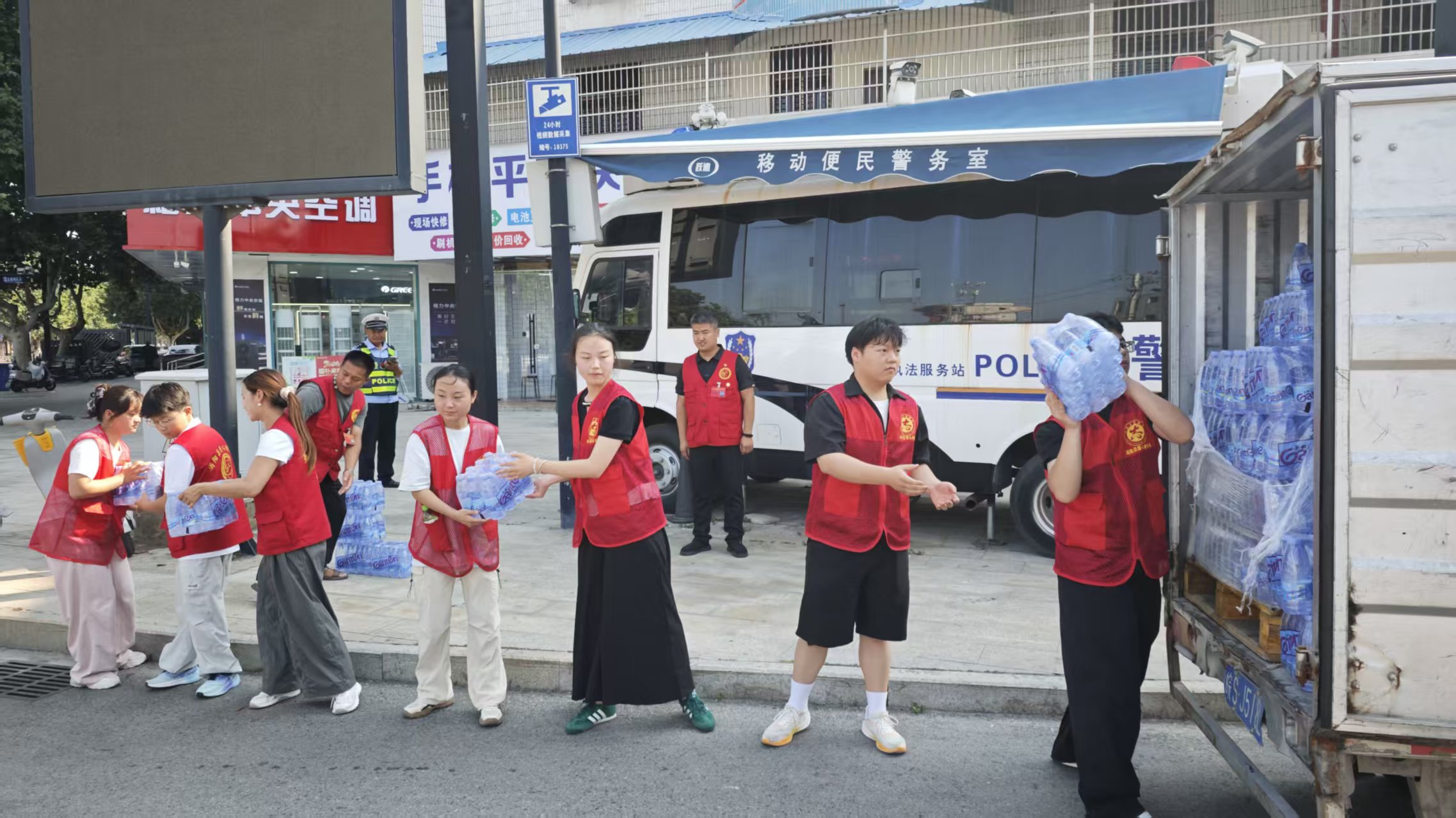 i_20260804154534614187.jpg 2志愿者们在酷暑难耐的高温天气下排队搬运水.jpg