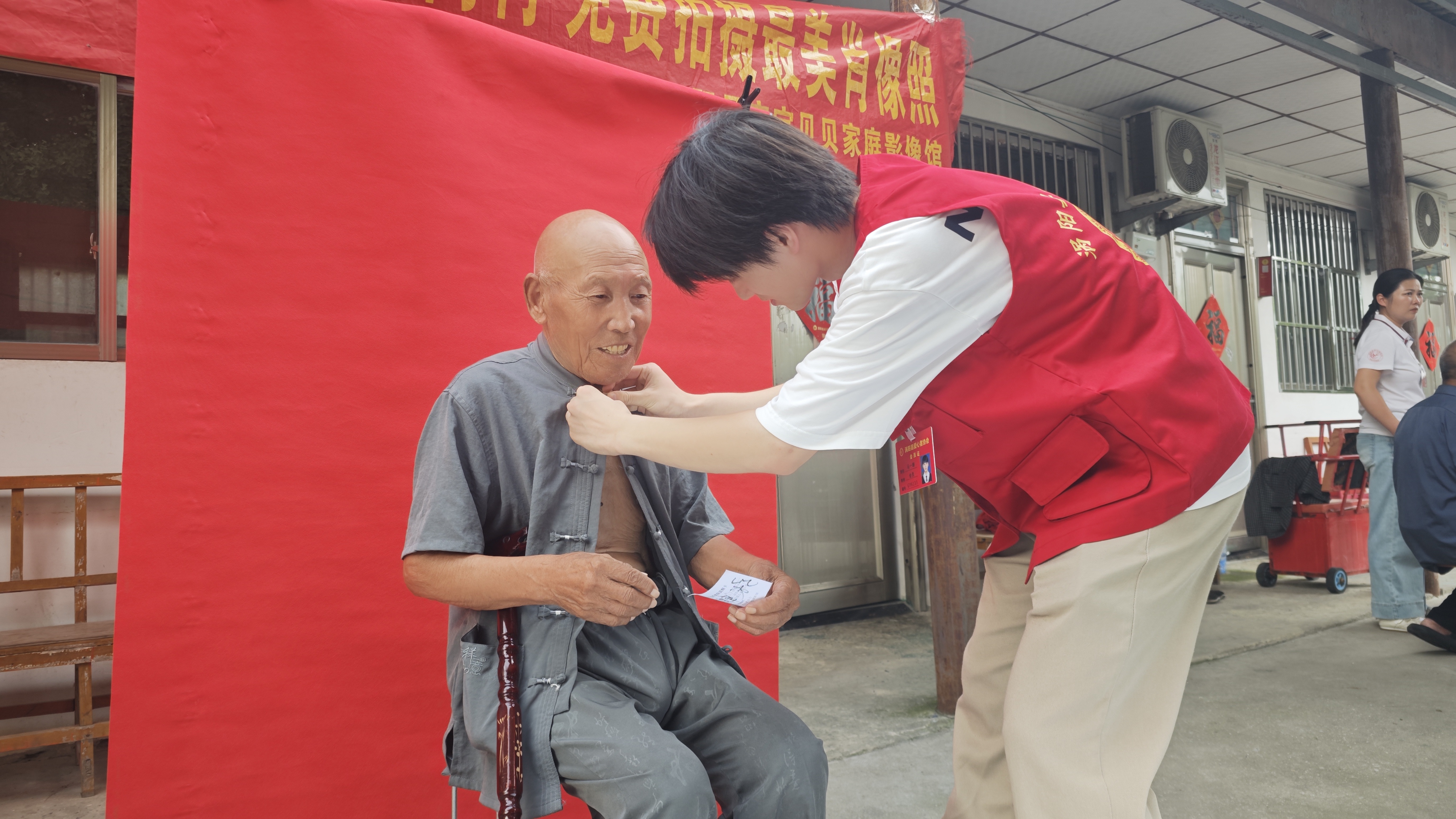 4大学生志愿者为老人整理衣衫扣扣子.jpg
